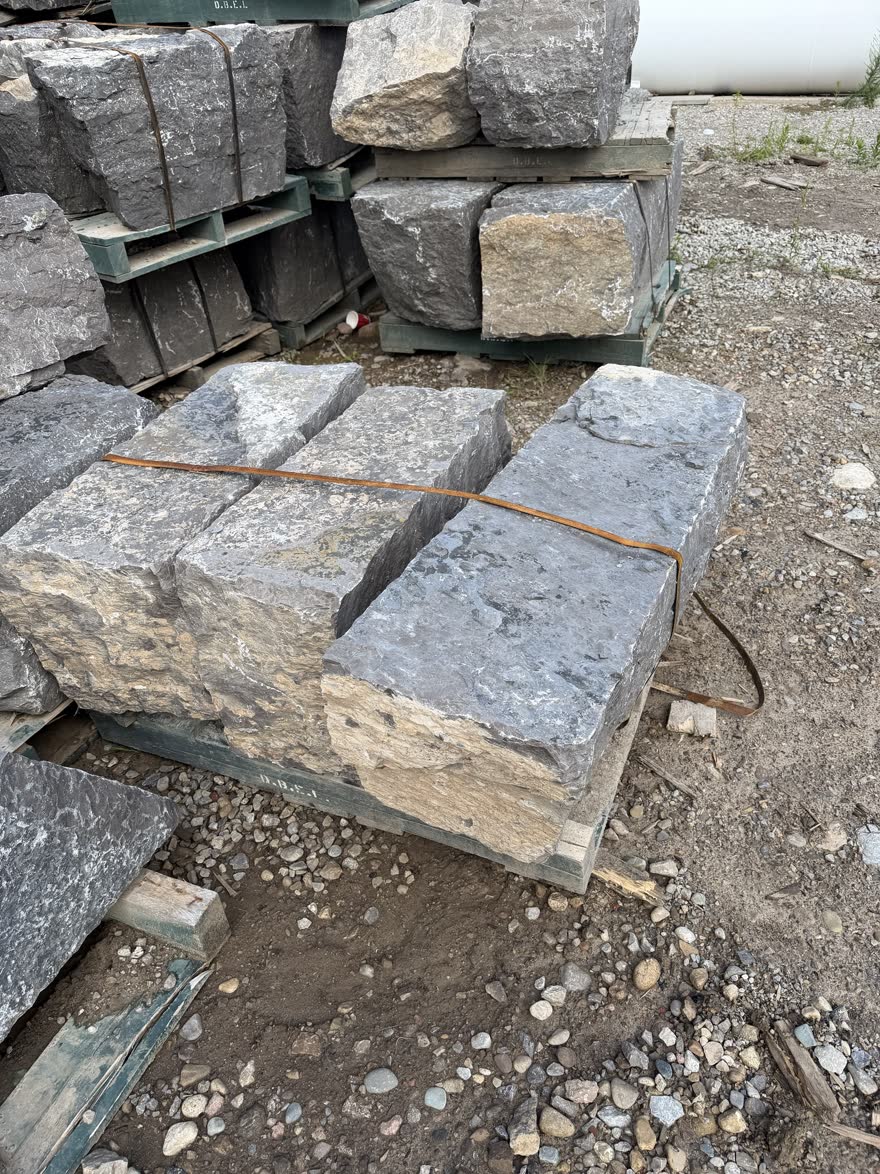 A pallet of long cut armour stone pieces strapped together at the stone yard